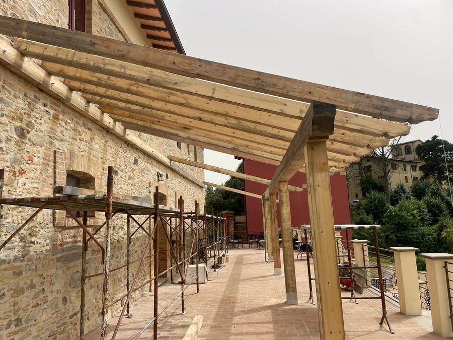 Pergolato in legno su facciata in pietra recuperata